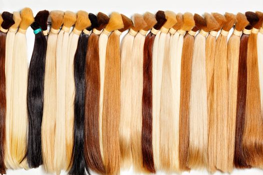 Bundles of natural long shiny healthy human hair of wheat shades, chocolate, brown. Hair care, style and women beauty concept.