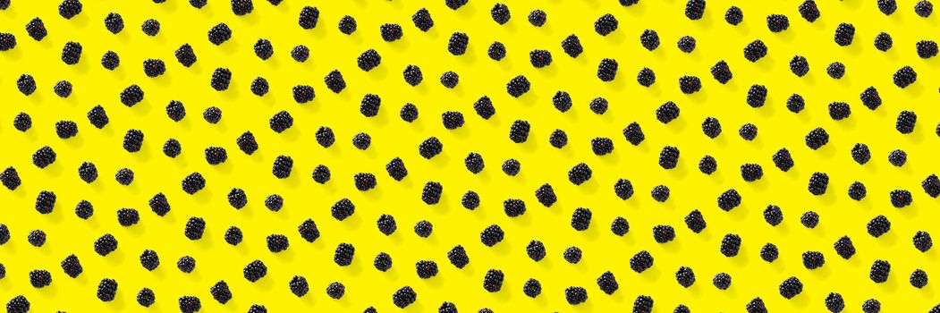 Background from isolated brambles. Group of tasty ripe blackberry isolated on yellow background. modern crative backround of falling blackberry or bramble.