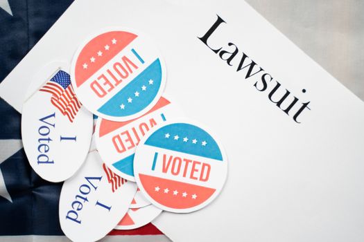 I voted stickers on Lawsuit paper with US flag as background - Concept of lawsuits in USA election