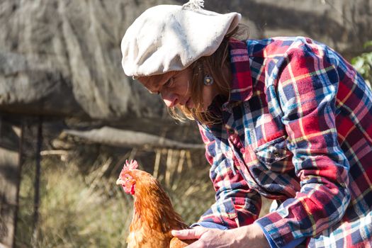 portrait of an Argentine farm worker woman with a hen