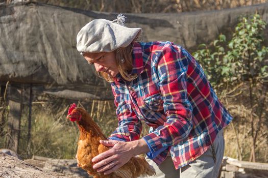 portrait of an Argentine farm worker woman with a hen