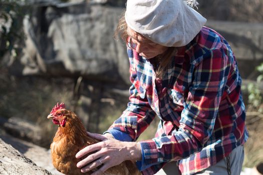 portrait of an Argentine farm worker woman with a hen