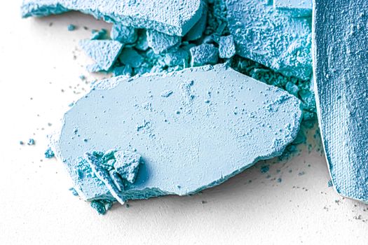 Blue eye shadow powder as makeup palette closeup isolated on white background, crushed cosmetics and beauty textures