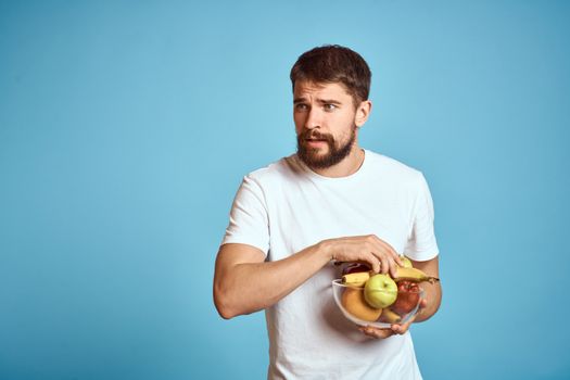 dark background handsome man with a beard holding fresh fruit and lifestyle transparent cup. High quality photo