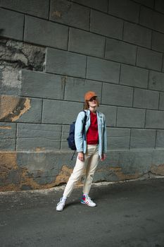 Girl tomboy photo in full growth. Street fashion. Relaxed posture
