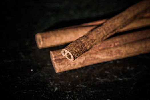 Cinnamon sticks on black stone background, food recipes
