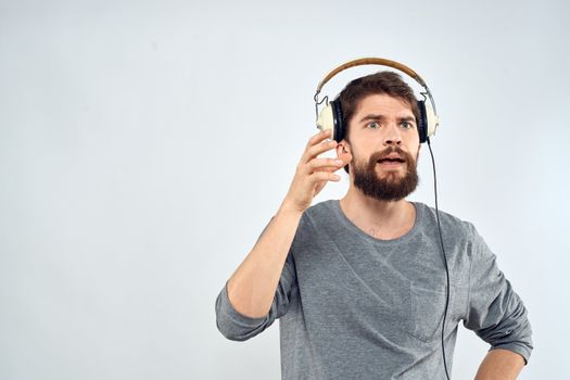 Man in headphones listens to music lifestyle modern style technology light background. High quality photo