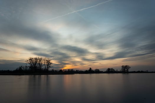 Clouds after sunset over a frozen lake, winter view