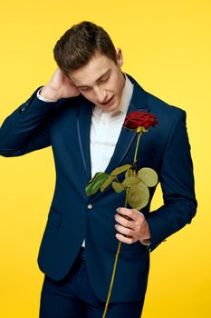 Gentlemen in classic suit on yellow background and red rose romance cropped view model portrait. High quality photo