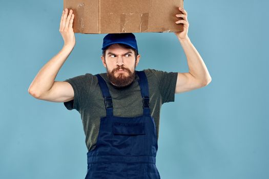 working man boxes in hands delivery service packaging lifestyle blue background. High quality photo