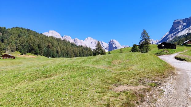 Val Gardena, Italy - 09/15/2020: Scenic alpine place with magical Dolomites mountains in background, amazing clouds and blue sky  in Trentino Alto Adige region, Italy, Europe