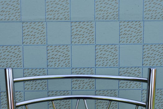 wall with vintage wallpaper, backrest of modern metal chair, background