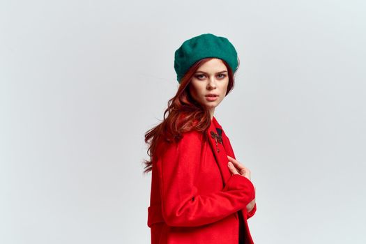 Woman in red coat and in green hat on isolated background cropped model with Copy Space emotions. High quality photo