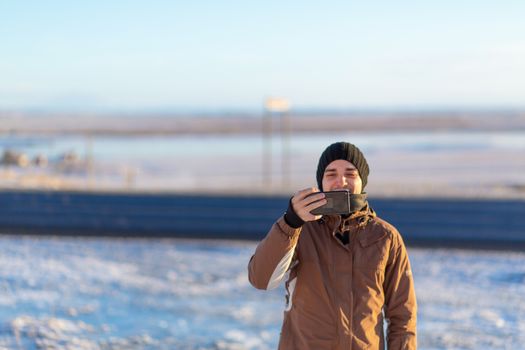 Guy tourist walks in winter in Iceland. Takes pictures of nature.