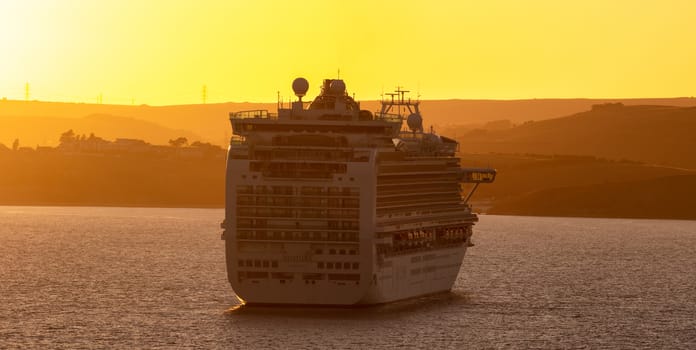 Weymouth Bay, United Kingdom - July 6, 2020: Beautiful panoramic shot of P&O cruise ship Ventura anchored in Weymouth Bay at sunset