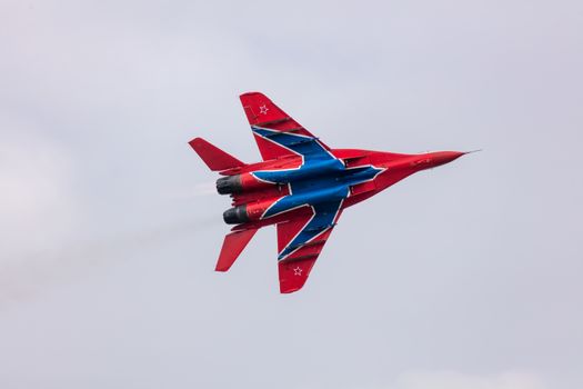 Barnaul, Russia - September 19, 2020: A close-up shot of Strizhi MiG-29 fighter jet performing stunts during an aeroshow. Blue cloudy sky as a background.