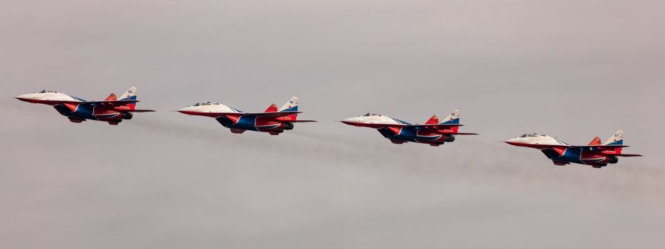 Barnaul, Russia - September 19, 2020: A low angle shot of Strizhi MiG-29 fighter jet squadron performing stunts during an aeroshow.