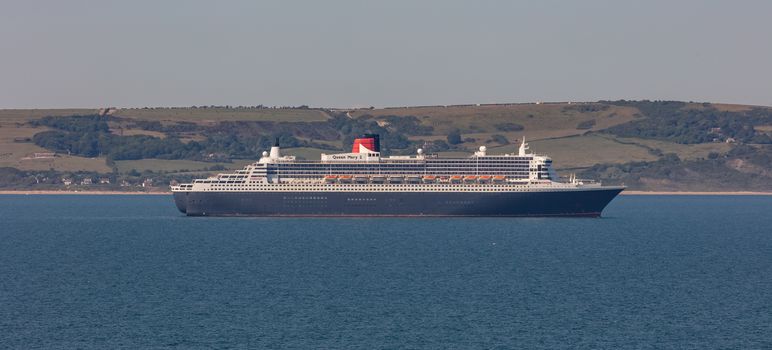 Weymouth Bay, United Kingdom - June 25, 2020: Beautiful panoramic shot of Cunard cruise ship Queen Mary 2 anchored in Weymouth Bay.