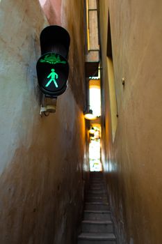 The architecture of the strago city of Prague. The narrowest street in Europe. The passage between buildings for one person, regulated by traffic lights.