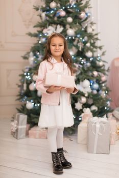 Happy childhood, magical Christmas tale. Little princess with Santa's present for Christmas.