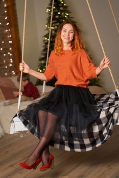 A beautiful redhead girl is swinging in her room on Christmas night.