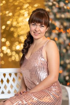 Stylish beautiful girl among sparkles and gerlands at a Christmas party.