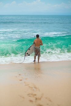 Surfer. Surfing Man With Surfboard Walking On Sandy tropical Beach. Healthy Lifestyle, water activities, Water Sport. Beautiful Ocean