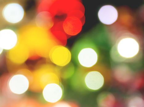 Defocused night street lights, blurred colorful bokeh background. Holiday colorful lanterns and light bulbs garlands.