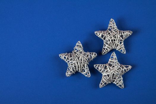 Brilliant silver Christmas star on blue background. Use for New Year's greetings. Minimal banner, copy space for text, flatlay.