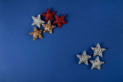 Brilliant red, gold, silver Christmas star on blue background. Use for New Year's greetings. Minimal banner, copy space for text, flatlay.