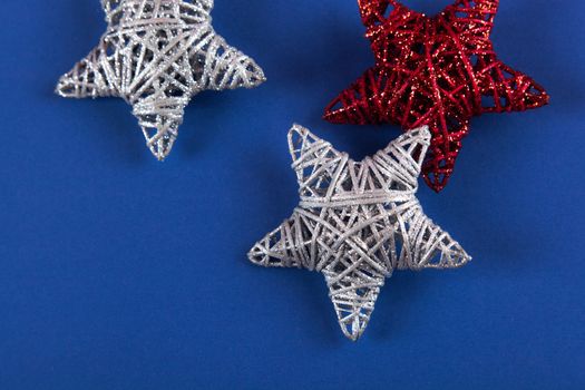Brilliant red silver Christmas star on blue background. Use for New Year's greetings. Minimal banner, copy space for text, flatlay.