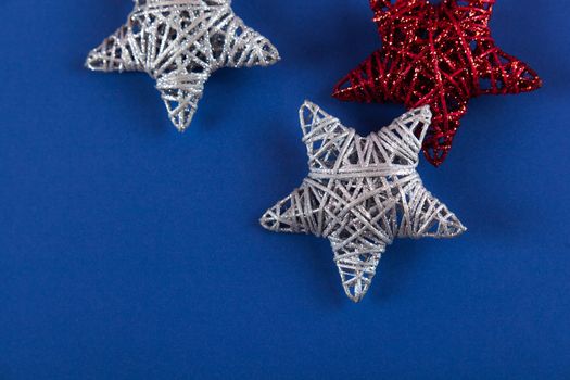 Brilliant red silver Christmas star on blue background. Use for New Year's greetings. Minimal banner, copy space for text, flatlay.