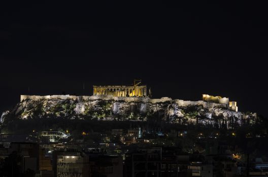 night view of the athens acropolis and modern buildings that surround the same