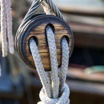 Old wooden pulley with ropes on a sailing ship