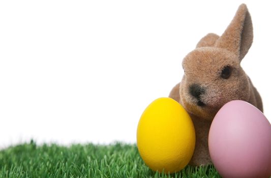 Easter bunny and two Easter eggs in the grass