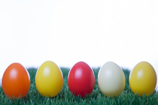 Various colored Easter eggs in a row with white background