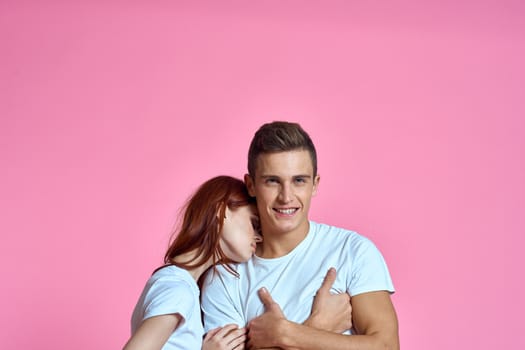 enamored man and woman hugging each other on a pink background cropped with Copy Space family portrait. High quality photo