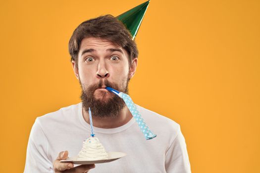 A bearded man with a cake and in a cap celebrating his birthday. High quality photo