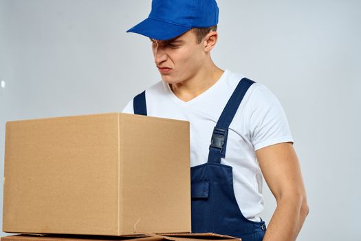 working man in uniform with boxes in his hands delivery loader lifestyle. High quality photo