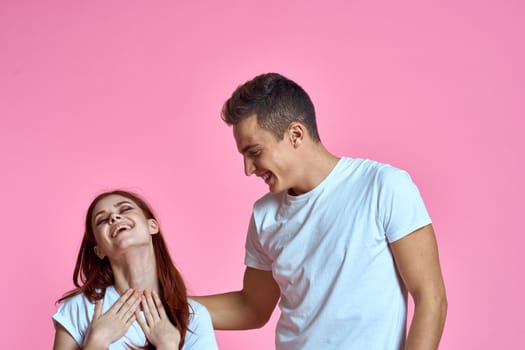 enamored man and woman hugging each other on a pink background cropped with Copy Space family portrait. High quality photo