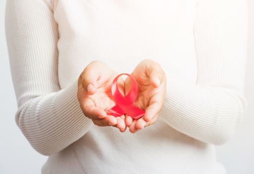 Breast cancer awareness healthcare and medicine concept. Close up Asian woman holding pink breast cancer awareness ribbon on hands treatment charity, studio shot isolated on white background