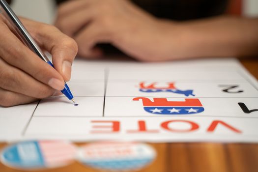 Close up of hands voting by selecting the political party at polling booth - Concept of polling at US election