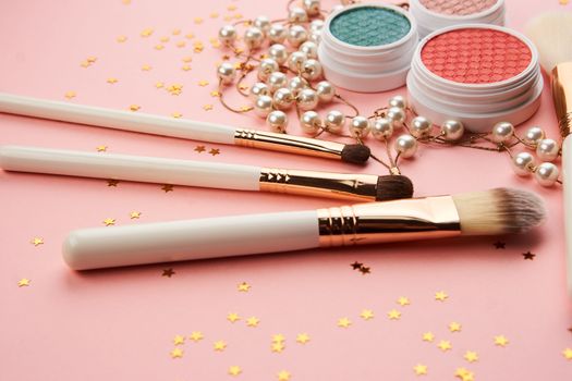 eyeshadow accessories beads makeup brushes collection professional cosmetics on pink background. High quality photo