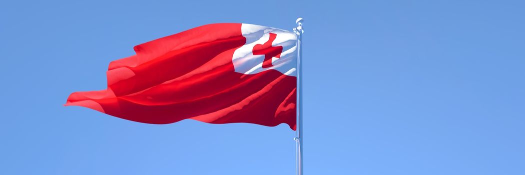 3D rendering of the national flag of Tonga waving in the wind against a blue sky