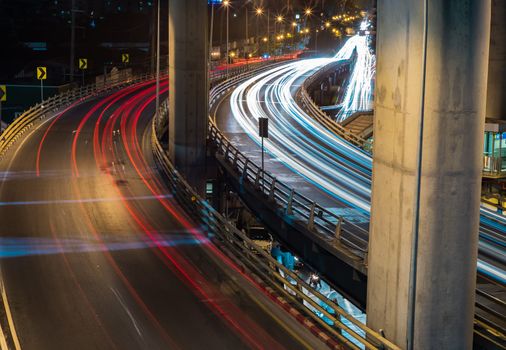 Overpass of the light trails with Bangkok city background at night. Beautiful curves. Selective focus.