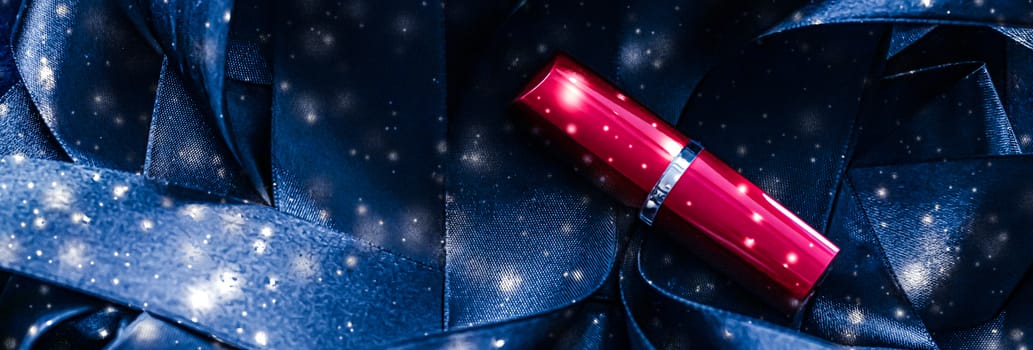 Red lipstick on blue silk and shiny glitter background, luxury make-up and beauty cosmetics