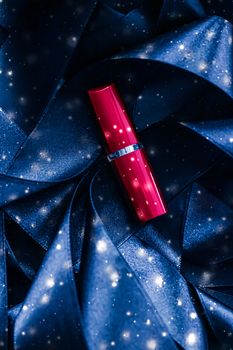 Red lipstick on blue silk and shiny glitter background, luxury make-up and beauty cosmetics