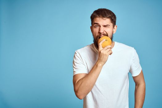 Bearded man with orange on blue background white t-shirt cropped view. High quality photo