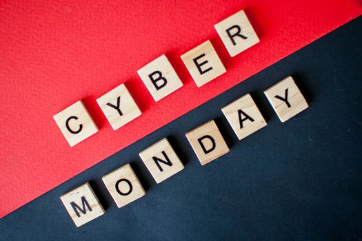 The inscription cyber monday from wooden blocks on a black and red background