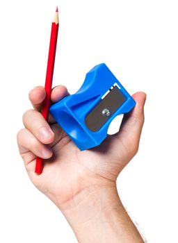 Male hand holding blue sharpener and red pencil, isolated on white background.